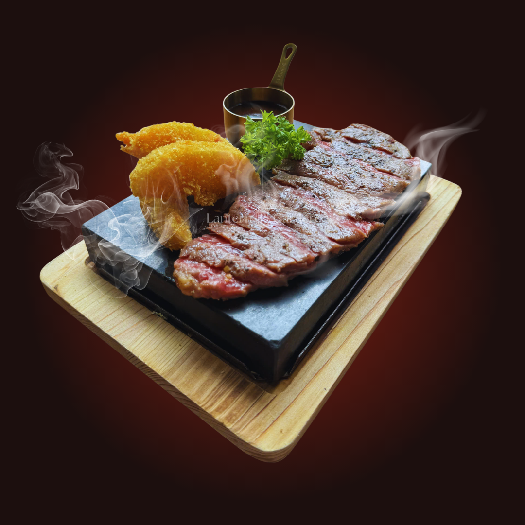 Fuji Beef Steak on a hot stone and a small pot on a wooden board.