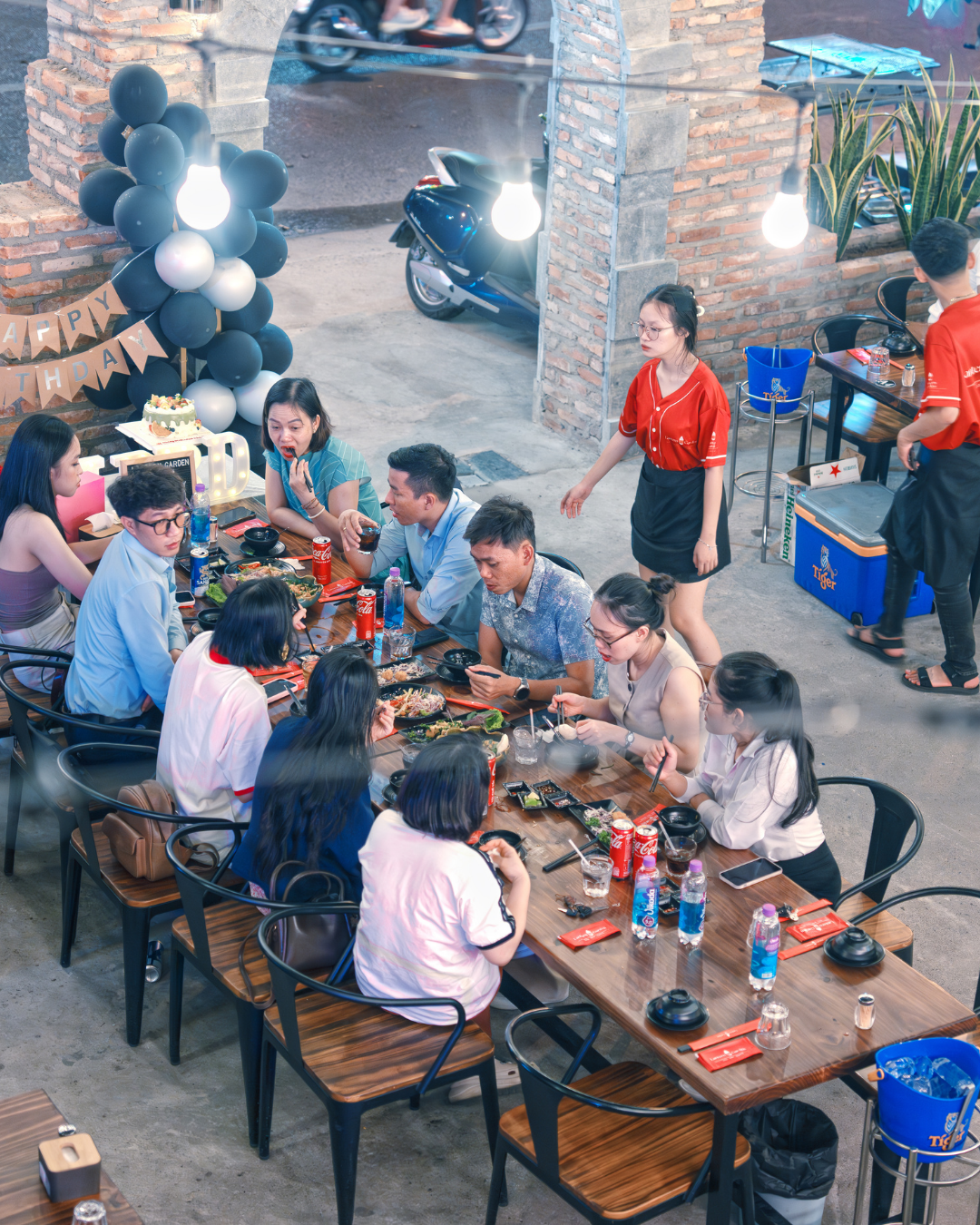 Group of people dining outdoors at Lantern Garden Nha Trang a casual restaurant setting.
